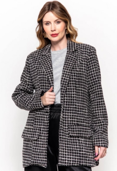 mulher usando um casaco tweed preto e branco com estampa geométrica