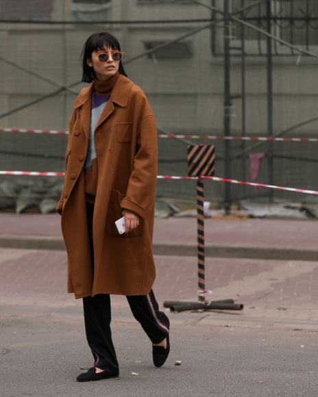 mulher usando casaco oversized com uma calça e mocassim preto