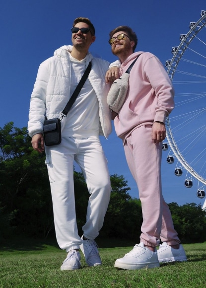 casal em frente a uma roda gigante com um look comfy para um festival de musica