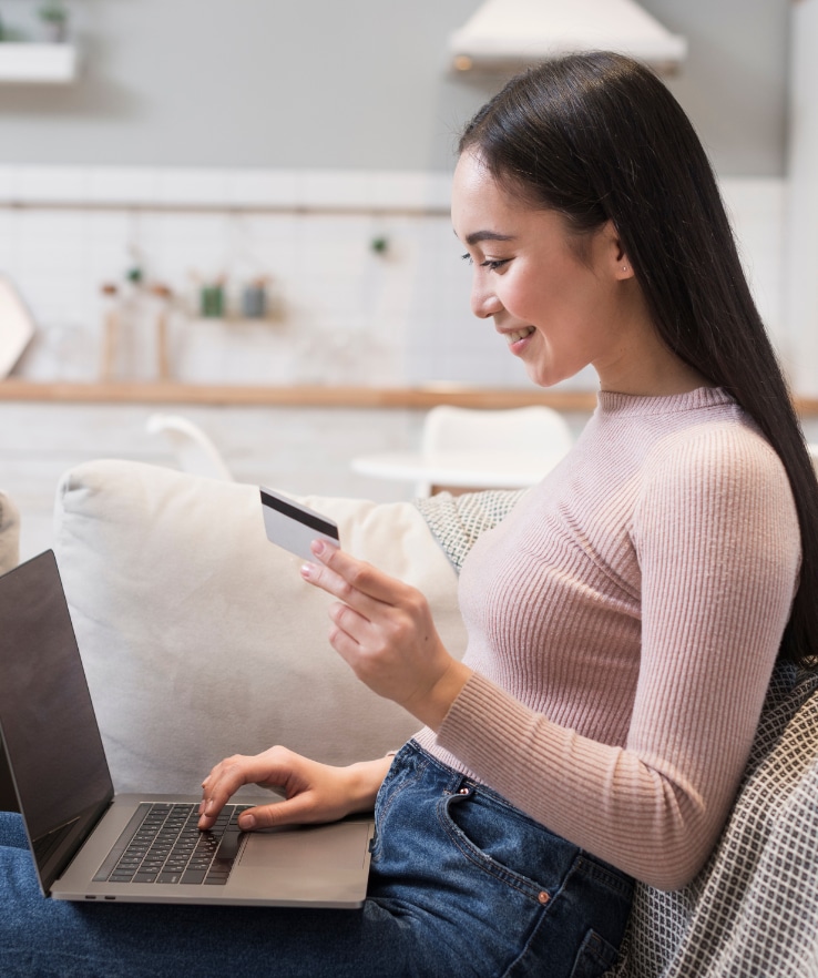 mulher sentada no sofá com notebook no colo fazendo compras de roupa online